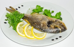 рыба с лимоном и зеленью на тарелке